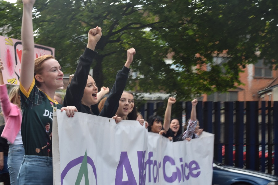 Manifestantes con los puños en alto tras una pancarta 'All for Choice'