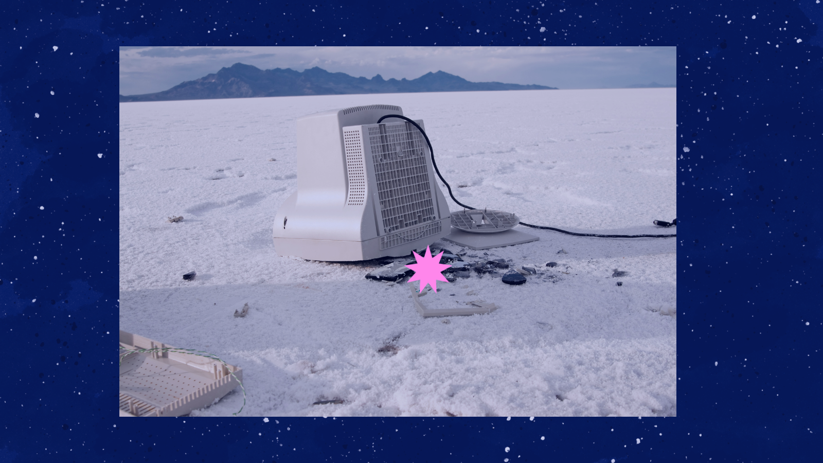 Un monitor de ordenador antiguo abandonado sobre un salar blanco con montañas al fondo
