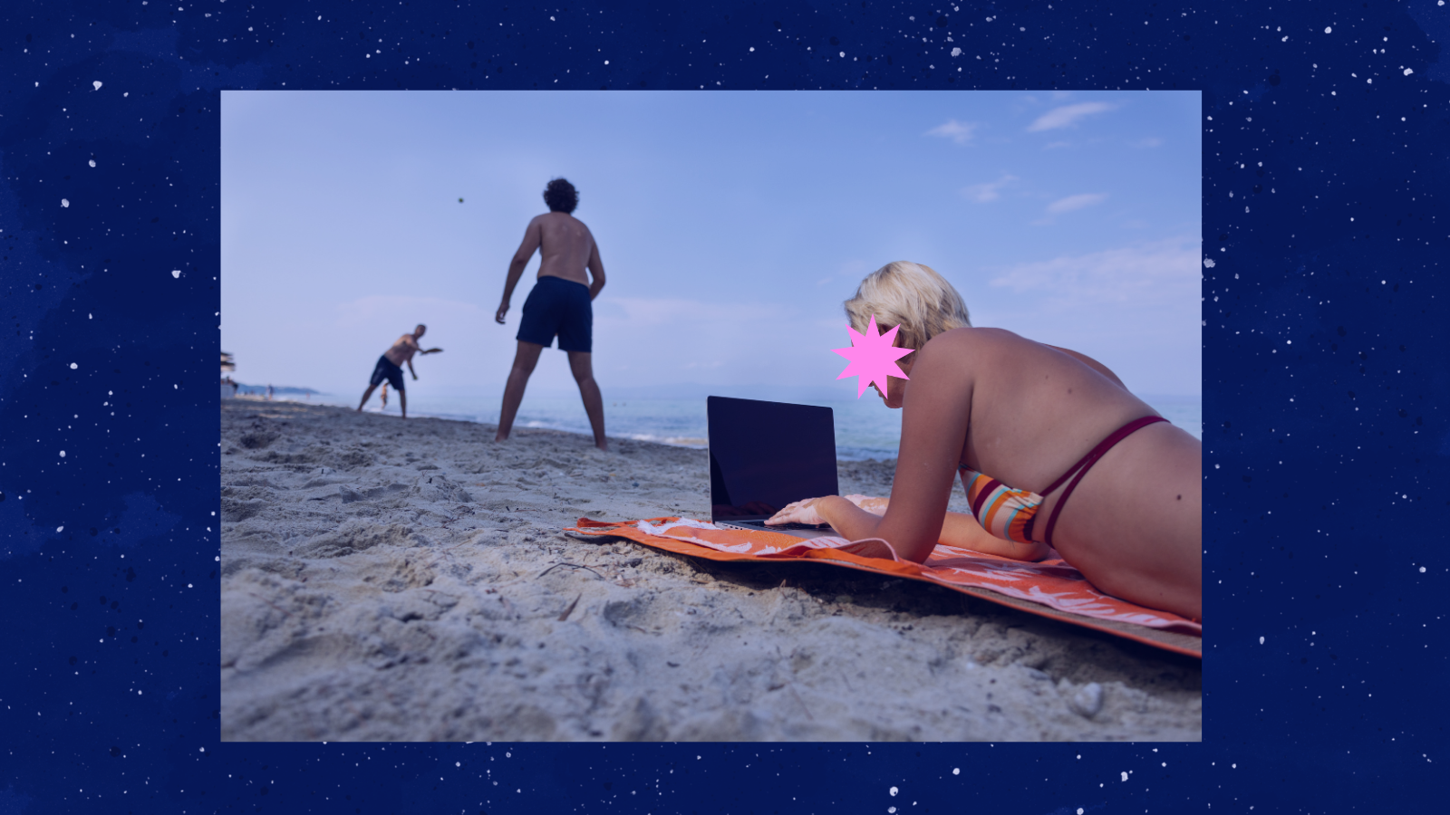 Una mujer trabaja con un portátil tumbada sobre una toalla en la playa